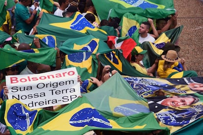 Los seguidores de Bolsonaro portan banderas y carteles antes de su investidura frente al Palacio de Planalto, en Brasilia.