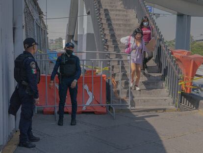 Dos policías resguardan la alcantarilla donde la noche anterior fallecieron dos muejeres.