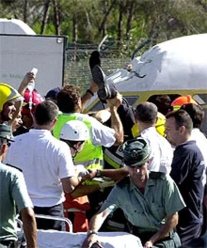 Un tripulante es rescatado de la cabina del avión.