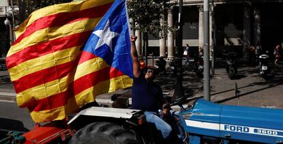 Un hombre, al volante de un tractor, porta una bandera independentista, este viernes.