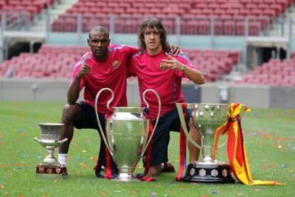 Puyol y Abidal posan con las tres copas ganadas en esta campaña.