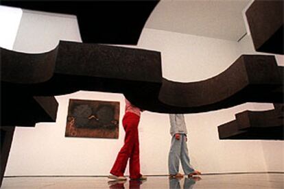 Escultura de Chillida y al fondo una de las pinturas de Tàpies depositadas en el Macba.