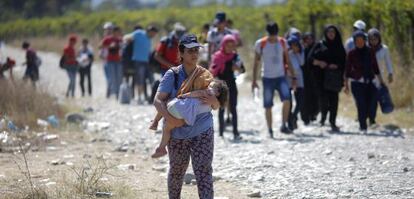 Un grupo de refugiados cruzan la frontera entre Grecia y Macedonia.-