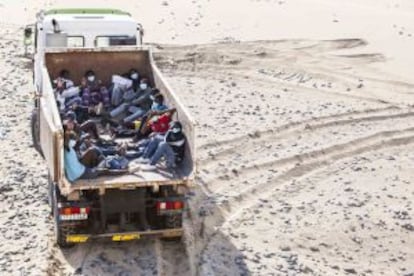 Immigrants sit inside a garbage truck at Maspalomas beach on Gran Canaria.