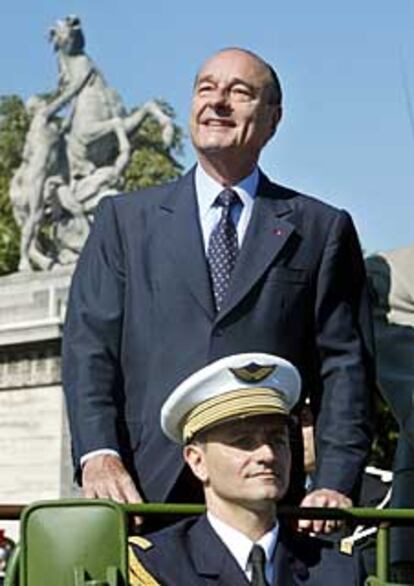 Chirac, ayer, a bordo de un coche descubierto a su llegada al desfile.