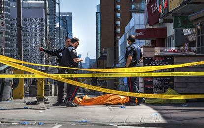 Varios Policías junto a un cuerpo de uno de los atropellados en Toronto