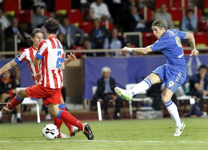 Fernando Torres chuta el balón mientras que Koke y Diego Godín intentan defenderlo.
