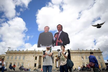 Dos hombres posan con los carteles de ambos candidatos en Bogotá.