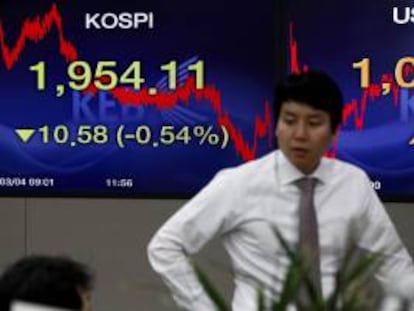 Corredores de bolsa trabajan junto a unas pantallas que muestran la información bursátil en Seúl (Corea del Sur). EFE/Archivo