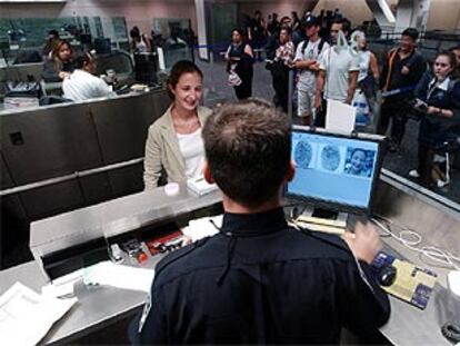 Un agente estadounidense de aduanas toma las huellas dactilares a una pasajera en el aeropuerto de San Francisco.