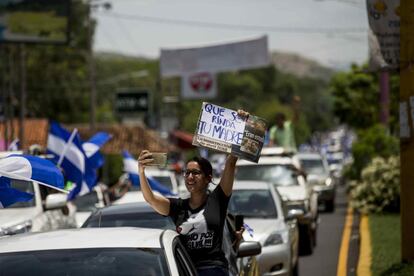 Uma mulher segura um cartaz com a frase "Que se renda sua mãe" —em resposta à petição de Ortega de que abandonassem as ruas— durante uma caravana na cidade de Masaya (Nicarágua) em apoio aos manifestantes dessa cidade que sofreram os ataques de polícias de choque e forças sandinistas, no dia 13 de maio de 2018.