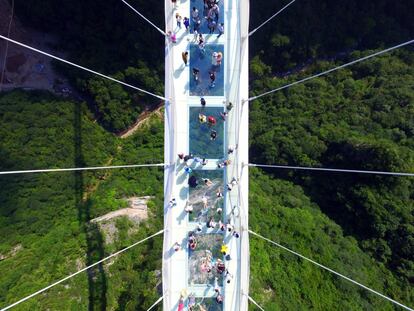 Visitantes caminan sobre un puente con suelo de cristal en Zhangjiajie en la provincia de Hunan (China).
