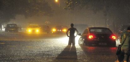 Un conductor observa la carretera inundada por las lluvias torrenciales en Pekín, el 21 de julio de 2012.