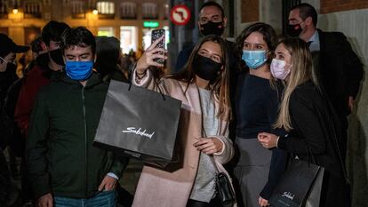 Varios jóvenes se sacan un selfi con la presidenta Isabel Díaz Ayuso poco antes de la entrada en vigor de las restricciones.