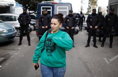 Fátima abandona la que fue su casa bajo la atenta mirada de los antidisturbios después del desahucio.