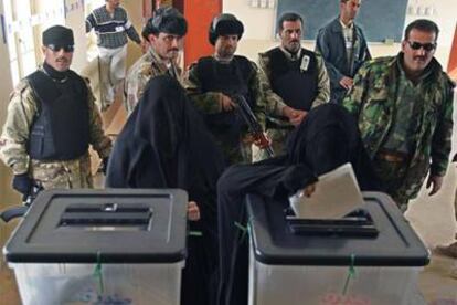 Dos mujeres votan ante cinco miembros de las fuerzas de seguridad iraquíes en Basora.