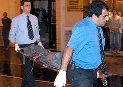 Dos empleados retiran el cuerpo del niño fallecido.