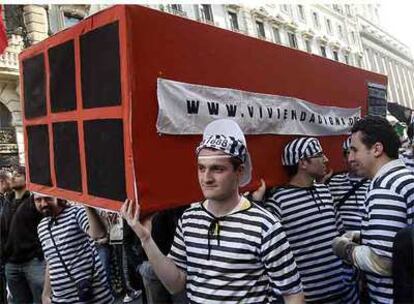 Varios manifestantes disfrazados de presidiarios portan un ladrillo para denunciar la especulación inmobiliaria ayer en Madrid.