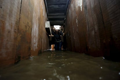 Una periodista fotografía el túnel de la vivienda por donde se escapó El Chapo durante la operación policial en Los Mochis.