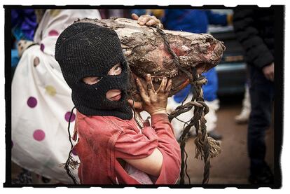 Un niño, con una cabeza de vaca al hombro, durante los carnavales de Ituren (Navarra). Febrero de 2016.