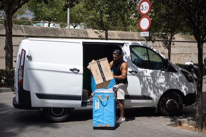 Un repartidor de Amazon organiza los paquetes junto a la furgoneta en el barrio de la Bordeta (Barcelona) en una imagen de archivo de 2022.