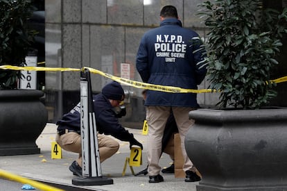 Police officers at the scene of the murder of Brian Thompson in Manhattan.