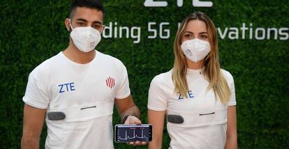 Dos jóvenes muestran en el estand de ZTE las camisetas 5G para monitorizar y transmitir constantes vitales. 