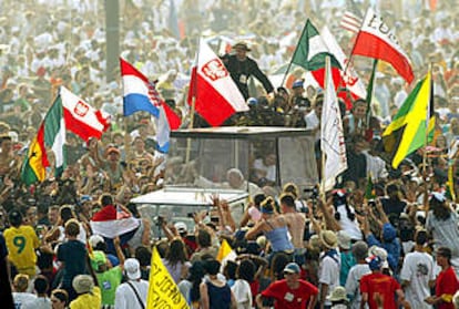 Juan Pablo II saluda desde el <b><i>papamóvil</b></i> a su llegada a la vigilia de la Jornada Mundial de la Juventud en Toronto.