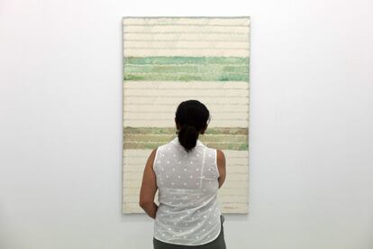 Una mujer observa la obra 'Después de la poda'. Acrílico sobre lienzo (1990).