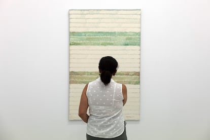 A woman views Caballero’s painting, 'After the Pruning’ (acrylic on canvas; 1990). 