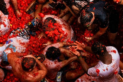 Jóvenes se lanzan pulpa de tomate durante la celebración de la Tomatina. 