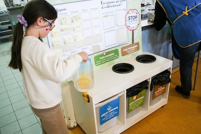 Alumnos de la escuela Joan Torredemer Canela de Matadepera (Barcelona) vierten el agua sobrante del comedor en un depósito, para después usarla para regar.