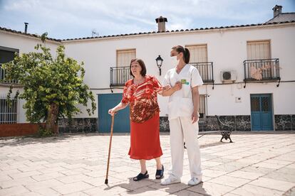 Juana Santamaría (izquierda), auxiliar del Servicio de Ayuda a Domicilio de Clece, camina junto a Ana Linares, de 74 años, por las calles de Carboneros (Jaén).