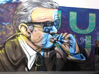 Un hombre pasea frente a un mural con una imagen de Juan Rulfo en Tuxcacuesco (México).