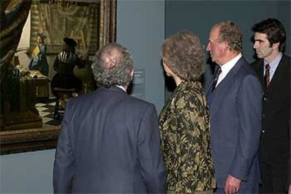 Los Reyes, junto al presidente del Patronato del Museo del Prado, Eduardo Serra (de espaldas), contemplan uno de los cuadros de la exposición &#39;Vermeer y el interior holandés&#39;, inaugurada en el Museo del Prado.