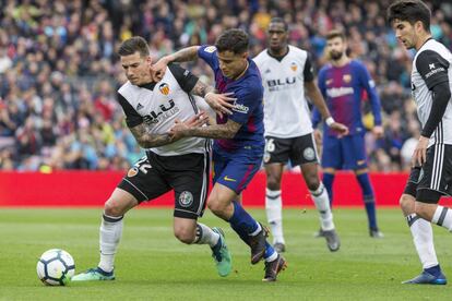 Santi Mina y Coutinho pelean por el balón.