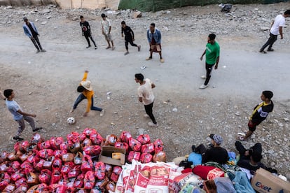 Un grupo de jóvenes juega al fútbol durante un descanso del reparto de ayuda en Souk, Aghbar. 