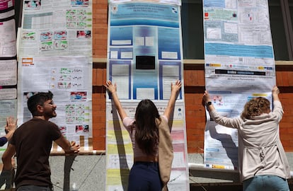 Profesores y alumnos sujetan el mural protesta de la facultad de Físicas de la UCM.