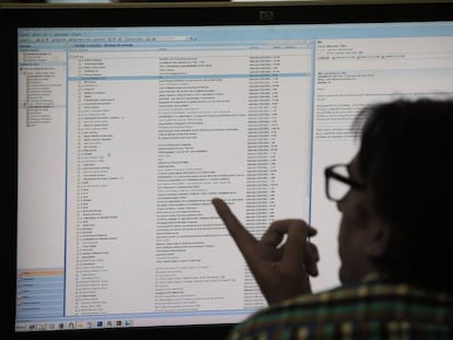 Un hombre consulta su correo electrónico en un ordenador en su puesto de trabajo. 