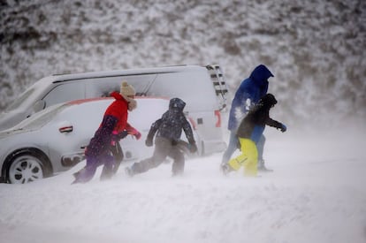 Varias personas juegan con la nieve en la localidad cántabra de Brañavieja, este domingo.