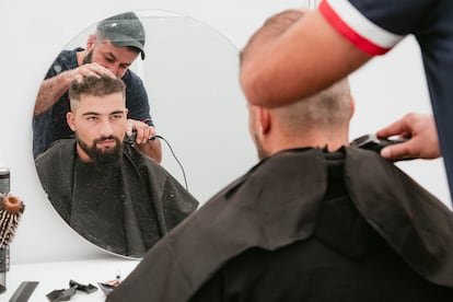 Ibrahim le corta el pelo a Mohammed en la peluquería en el Centro de Refugiados de Tegel, el 24 de octubre.