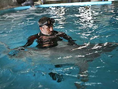 Un técnico de Aquarium Barcelona ayuda a nadar en un tanque al tiburón capturado en Tarragona.