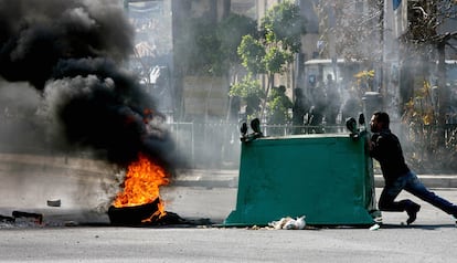 Un manifestante mueve un contenedor para crear una barricada durante la protesta a favor del primer ministro saliente Hariri.