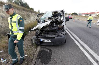 Miembros de la Guardia Civil ante los restos de uno de los coches implicados en un accidente mortal de tráfico en la localidad de Moixent, en Valencia.