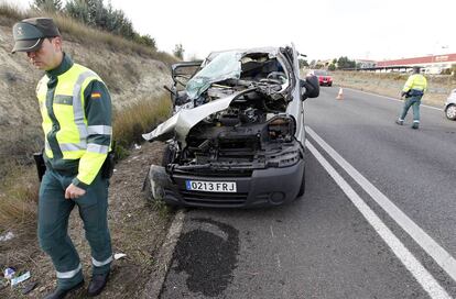 Miembros de la Guardia Civil ante los restos de uno de los coches implicados en un accidente mortal de tr&aacute;fico en la localidad de Moixent, en Valencia.