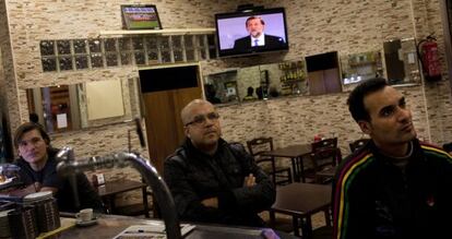 Un grupo de personas sigue el debate en un bar de Barcelona.
