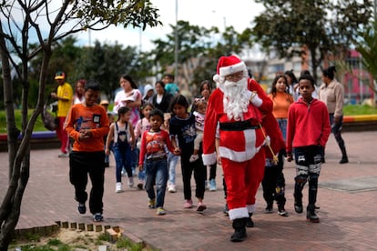 Un hombre vestido de Pap Noel reparte juguetes donados a los ni?os del barrio de San Bernardo, el 20 de diciembre en Bogot, Colombia. 