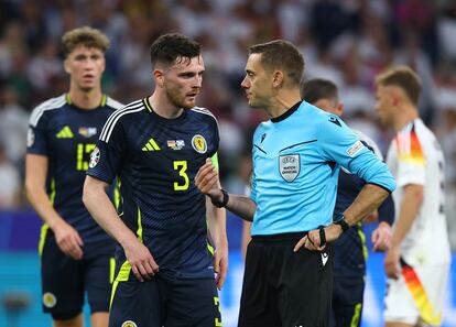 El árbitro Clement Turpin charla con el capitán de Escocia, Andy Robertson, en el partido ante Alemania.