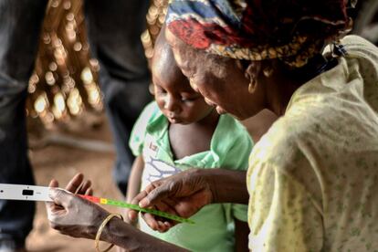 Para garantizar la sostenibilidad del proyecto de la lucha contra la desnutrición en Níger, MSF involucraba a la comunidad tanto como fuera posible. Una vez que los voluntarios de la comunidad fueron capacitados, su cometido era ir de puerta en puerta para conocer a las madres de forma individual y realizar sesiones de sensibilización y formación sobre cómo utilizar la Cinta MUAC (circunferencia del brazo medio superior) con la que se detectan casos de desnutrición en la infancia. En la imagen, una abuela mira la cinta que un voluntario de la comunidad le acaba de dar.