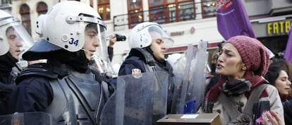 Una activista de los derechos de las mujeres se enfrenta a la policía antidisturbios el domingo en Estambul.